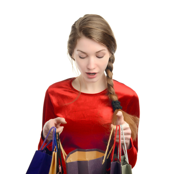 Jovem mulher olhando dentro dos sacos de compras
 - Foto, Imagem