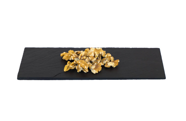 Group of nuts on a slate plate on a white background - Photo, Image
