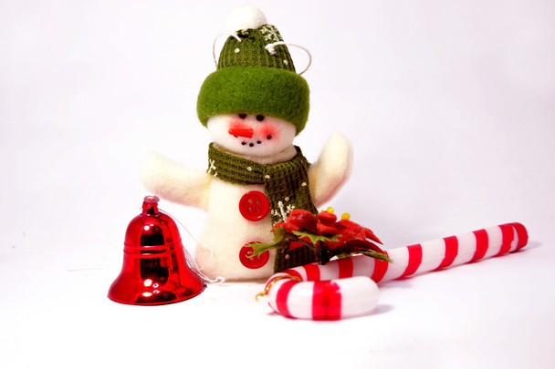 χιονάνθρωπος με Χριστούγεννα κουδούνι και καραμέλα από ζαχαροκάλαμο - Φωτογραφία, εικόνα
