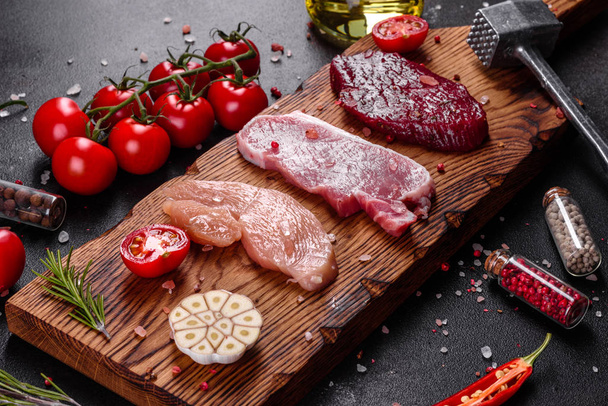 Steak juteux frais de bœuf, porc et poulet avec légumes prêts à cuire. Steaks de différentes variétés de viande préparés pour la cuisson
 - Photo, image