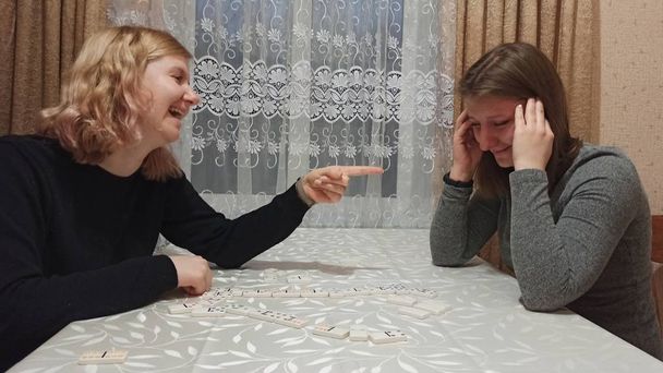 Jonge meisjes spelen domino aan tafel - Foto, afbeelding