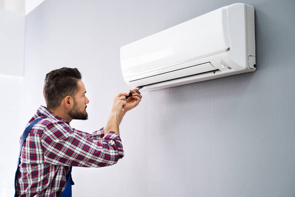 Happy Male Technician Repairing Air Conditioner With Screwdriver - Foto, Imagem