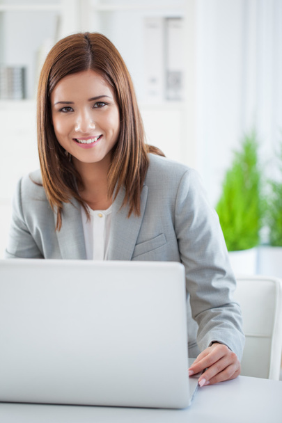 Lächelnde Geschäftsfrau an ihrem Laptop - Foto, Bild