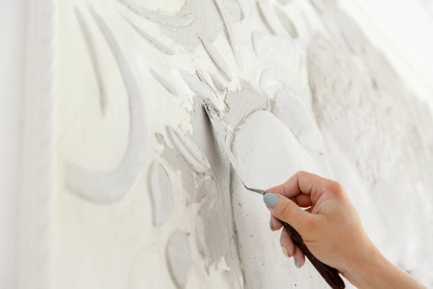work process, woman worker puts putty solution on the wall with a bas-relief - Zdjęcie, obraz