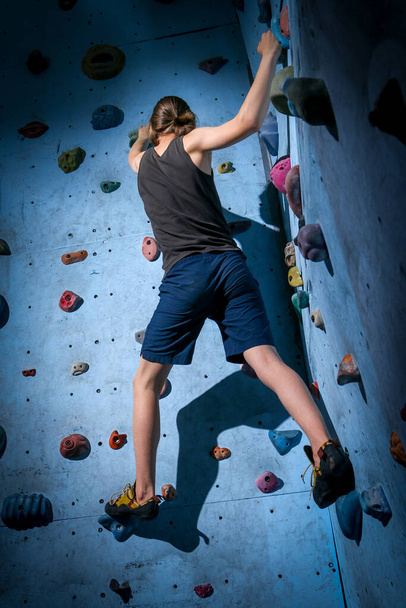 Genç çocuk üzerinde kapalı tırmanma duvarı tırmanma eğitimi - Fotoğraf, Görsel