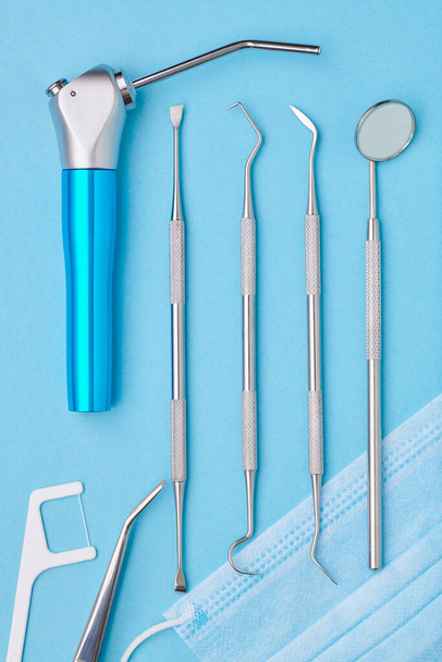 Narzędzia dentystyczne na jasnoniebieskim tle widok z góry płaski leżak. Pielęgnacja zębów, higiena jamy ustnej i koncepcja zdrowia.  - Zdjęcie, obraz