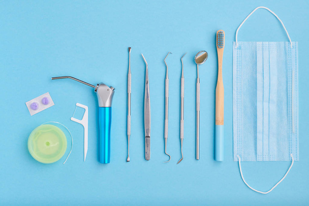 Dentist tools over light blue background top view copy space flat lay. Tooth care, dental hygiene and health concept.  - Fotografie, Obrázek