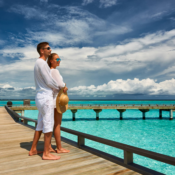Couple on a tropical beach jetty at Maldives - Photo, Image