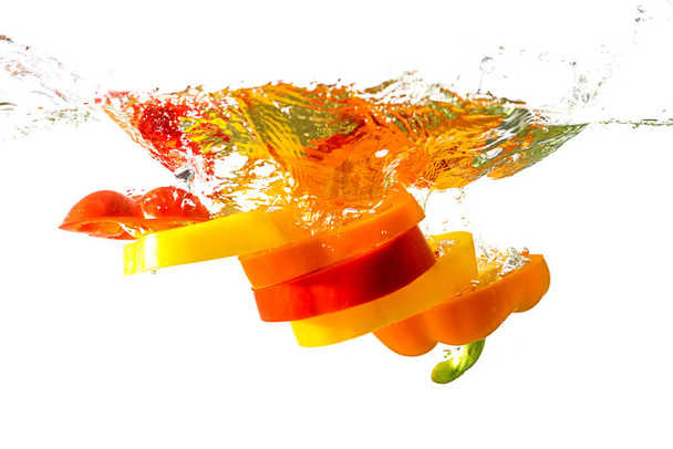 Orange, rote und gelbe Paprika in Scheiben geschnitten auf weißem Hintergrund. Konzept der gesunden Ernährung. - Foto, Bild