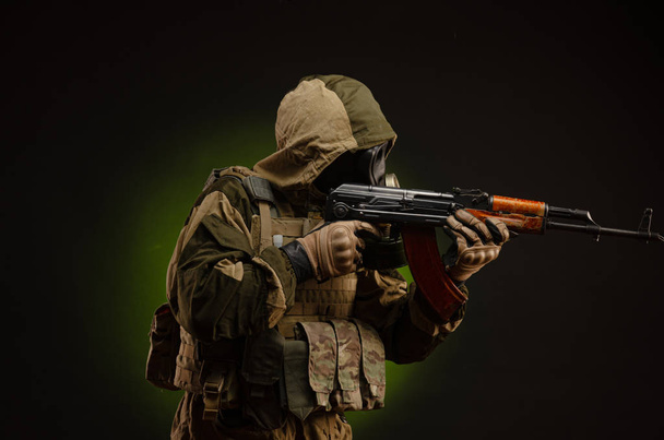 soldado Stalker sabotador em uniforme militar com um rifle Kalashnikov em um fundo escuro em uma máscara de gás
 - Foto, Imagem
