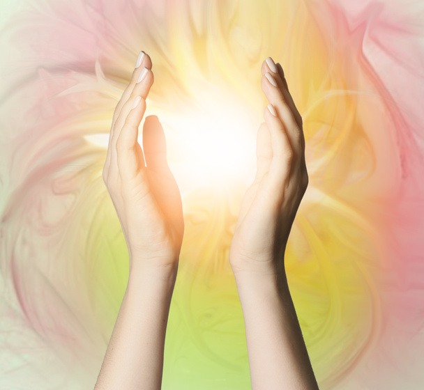 Женские руки с сияющей энергией на цветном фоне
 - Фото, изображение