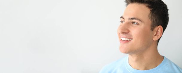 Schöner lächelnder Mann auf hellem Hintergrund mit Platz für Text - Foto, Bild