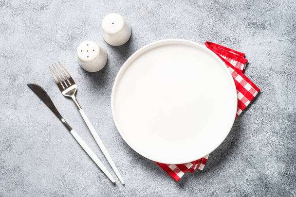 Table setting with white plate and cutlery top view. - Fotografie, Obrázek