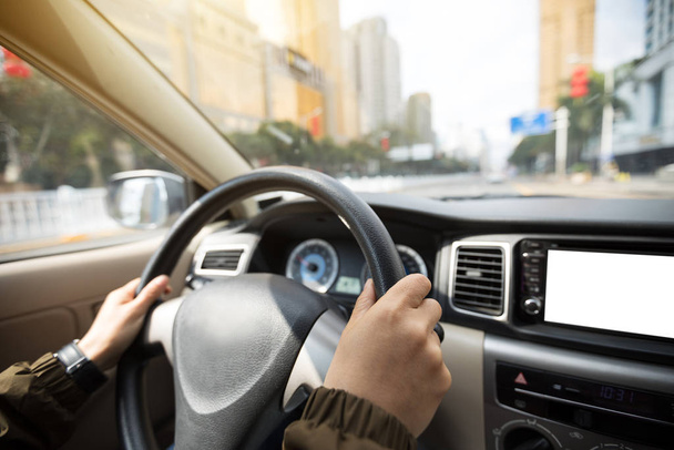 Manos de mujer conduciendo coche en la calle de la ciudad
 - Foto, imagen