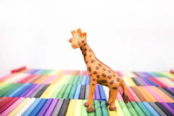 Hrát hliněná zvířata. Žirafa na barevném pozadí. - Fotografie, Obrázek