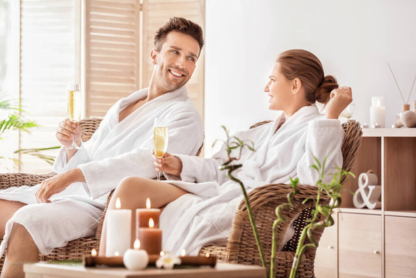 Young couple with glasses of champagne relaxing in spa salon - Photo, Image