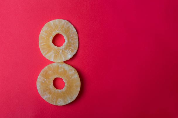 két ananász gyűrű piros háttérrel - Fotó, kép