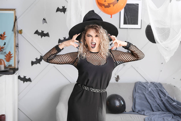 Beautiful woman dressed as witch for Halloween at home - Foto, afbeelding