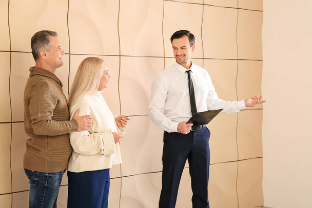 Male real estate agent showing mature couple a new house - Photo, Image