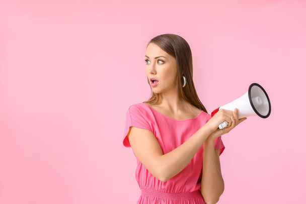 Young woman with megaphone on color background - Photo, Image