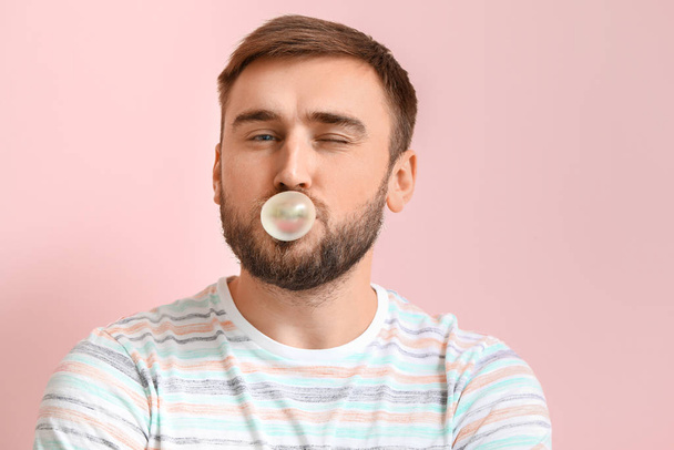 Vtipný muž s žvýkačkou na barevném pozadí - Fotografie, Obrázek