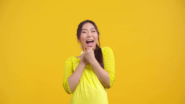 ενθουσιασμένο κορίτσι από το Καζακστάν γιορτάζει θρίαμβο απομονωμένο στο κίτρινο  - Πλάνα, βίντεο