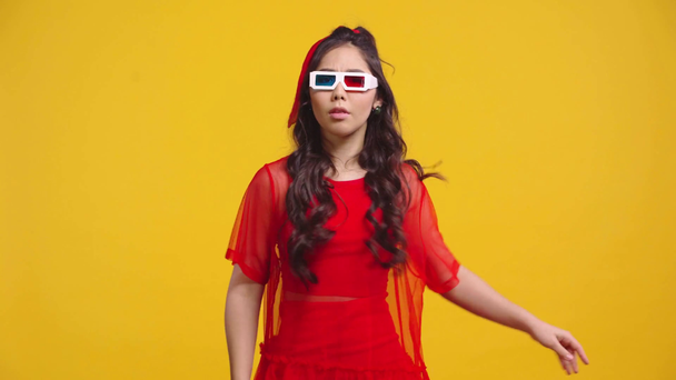 asiatische Mädchen in 3D-Gläsern werfen Popcorn isoliert auf gelb  - Filmmaterial, Video