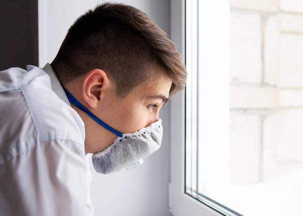 Young Man in a Flu Mask by the Window in the Room - Foto, Bild
