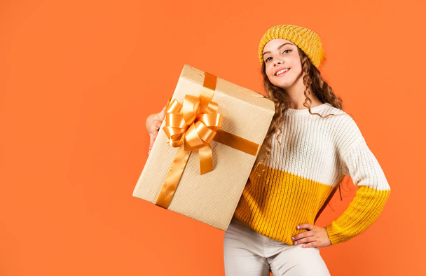 Birthday tradition. Pretty teen makeup face curly hairstyle. Kid hold present box. Shopping mall. Birthday celebration idea. Fashionable little girl wear knitted hat and sweater. Birthday surprise - Fotoğraf, Görsel