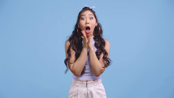 opgewonden aziatisch meisje gebaren en vieren geïsoleerd op blauw  - Video