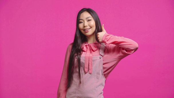 menina kazakh alegre mostrando polegar para cima isolado em rosa
  - Filmagem, Vídeo