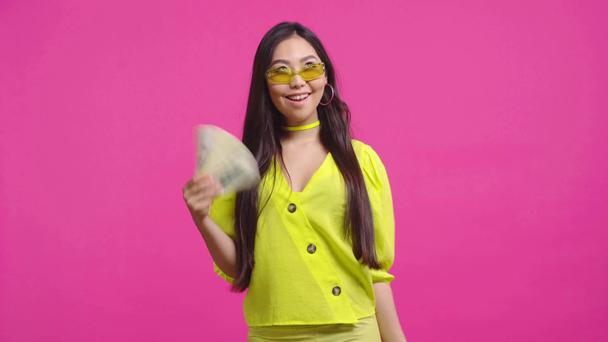 stijlvol aziatisch meisje zwaaien geld geïsoleerd op roze  - Video