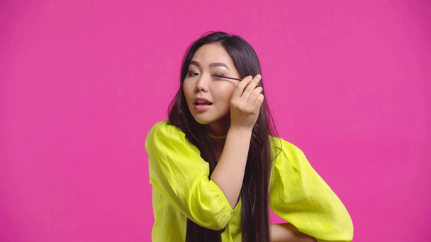 bonita menina kazakh aplicando rímel isolado em rosa
  - Filmagem, Vídeo