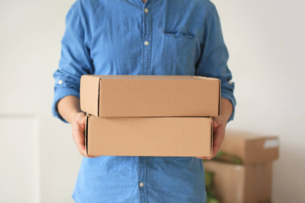 Человек с коробками дома в день переезда
 - Фото, изображение