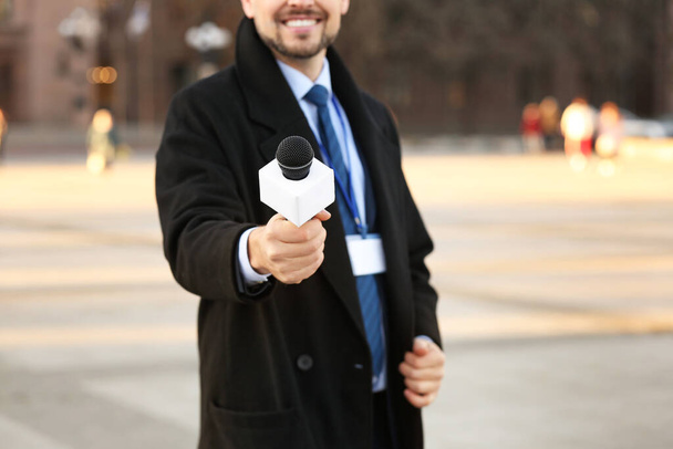 Männlicher Journalist mit Mikrofon draußen - Foto, Bild