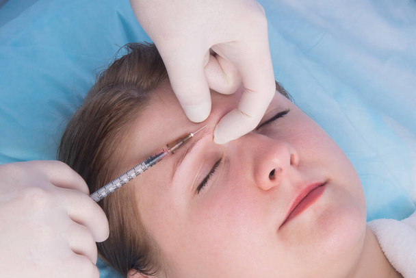 cosmetology, prick a woman's eyebrow, to improve growth - Foto, afbeelding