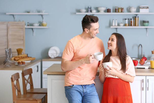 Young couple drinking tea together in kitchen - Foto, imagen