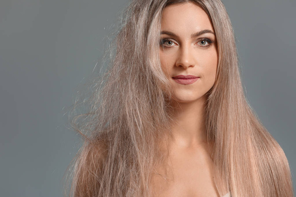 Beautiful young woman before and after hair treatment on grey background - Photo, Image