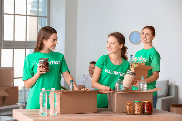 Equipo de voluntarios con productos en interiores
 - Foto, Imagen