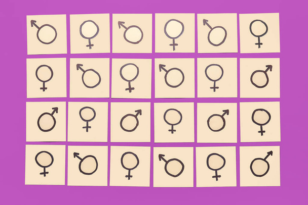Many paper sheets with drawn symbols of man and woman on color background. Concept of feminism - Photo, Image