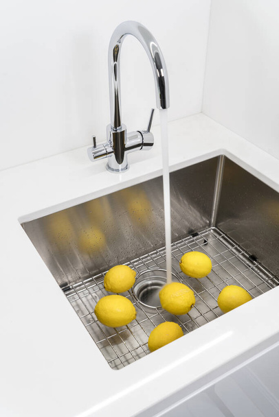 Laver les citrons dans l'évier de cuisine
. - Photo, image