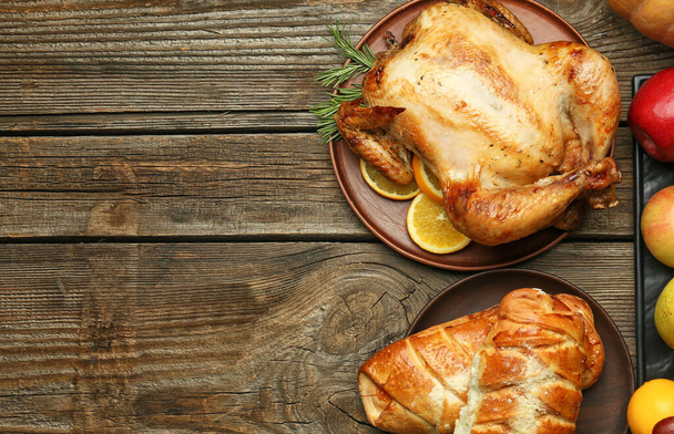 Tasty baked turkey and different food for Thanksgiving day on wooden table - Photo, Image