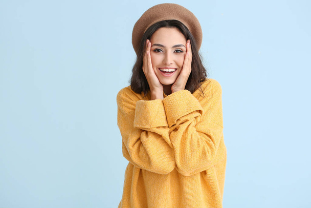Beautiful young woman in warm sweater on color background - Φωτογραφία, εικόνα