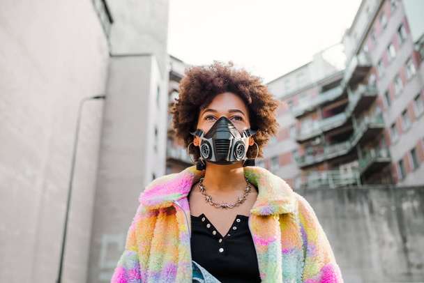 Jonge vrouw poseren buiten in Milaan dragen medisch masker te beschermen tegen vervuiling en virus - anti-smog, infectie, bescherming concept - Foto, afbeelding