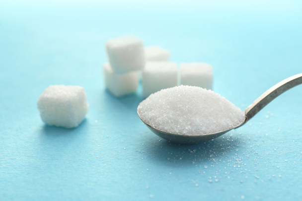 Spoon with sweet sugar on color background - Foto, Imagem