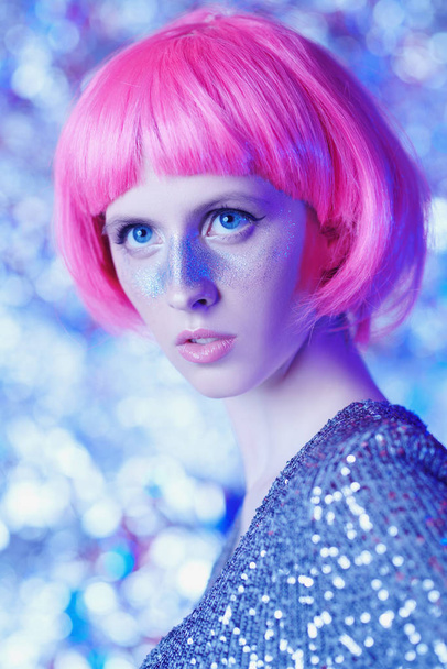 Férias e estilo festa. Retrato de uma menina atraente com sardas brilhantes e uma peruca rosa brilhante. Conceito de beleza, maquiagem e cosméticos
. - Foto, Imagem