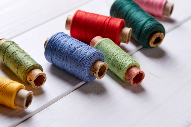 bobbins with thread on wooden background, close view - 写真・画像
