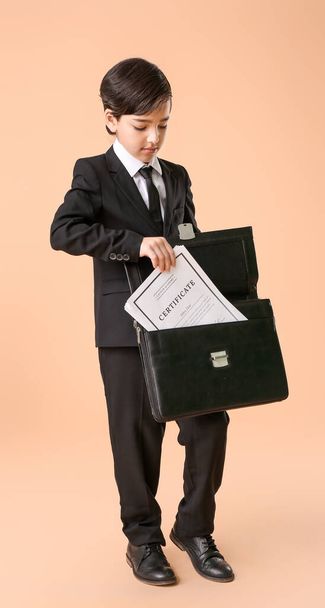 Kleine advocaat zet document in aktetas op kleur achtergrond - Foto, afbeelding
