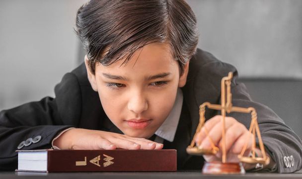 Little lawyer with scales of justice and book in office - Photo, Image