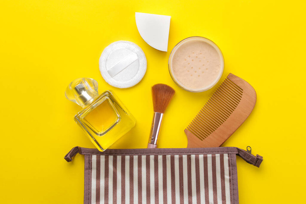 Kit trucco. Cosmetici delle donne in una borsa cosmetica e pennelli per il trucco su uno sfondo giallo brillante. Cose da donne. vista dall'alto
 - Foto, immagini